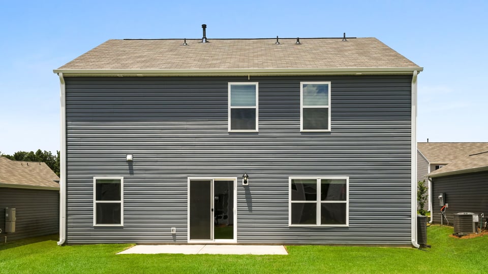 Back exterior of home with large backyard.