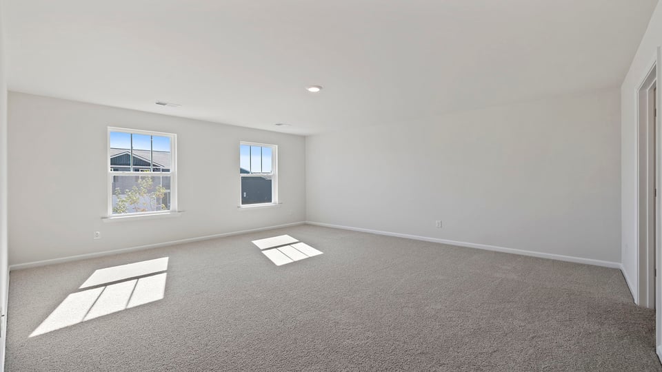 Primary bedroom with large windows.