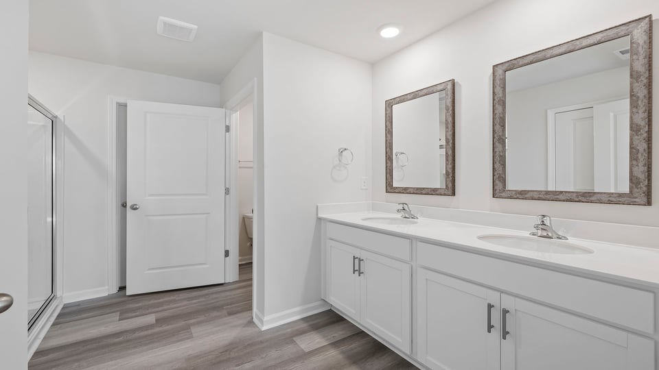 Primary bathroom with dual sinks and walk-in shower.