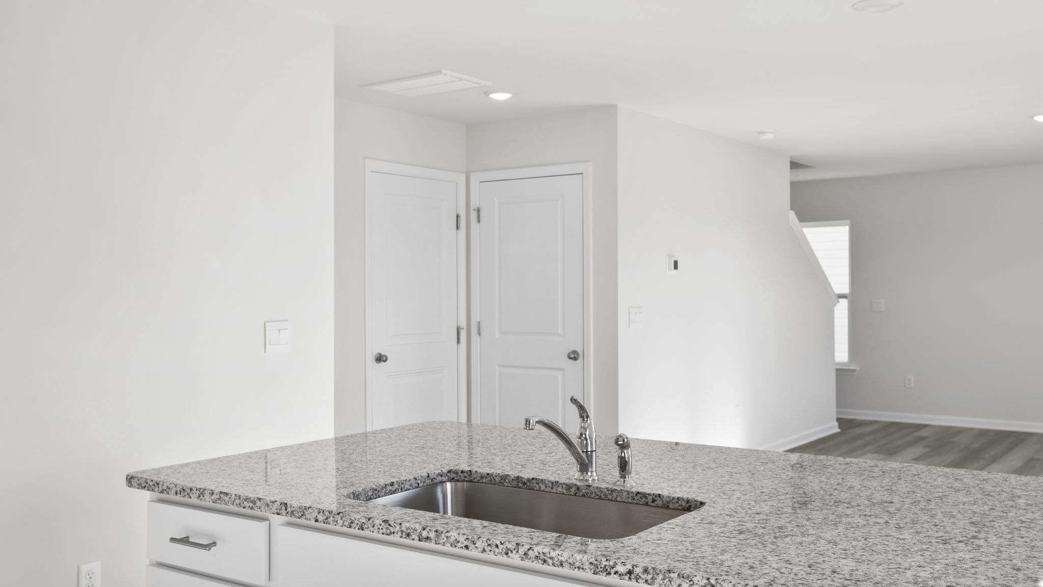 Kitchen island hosts the sink and dishwasher.