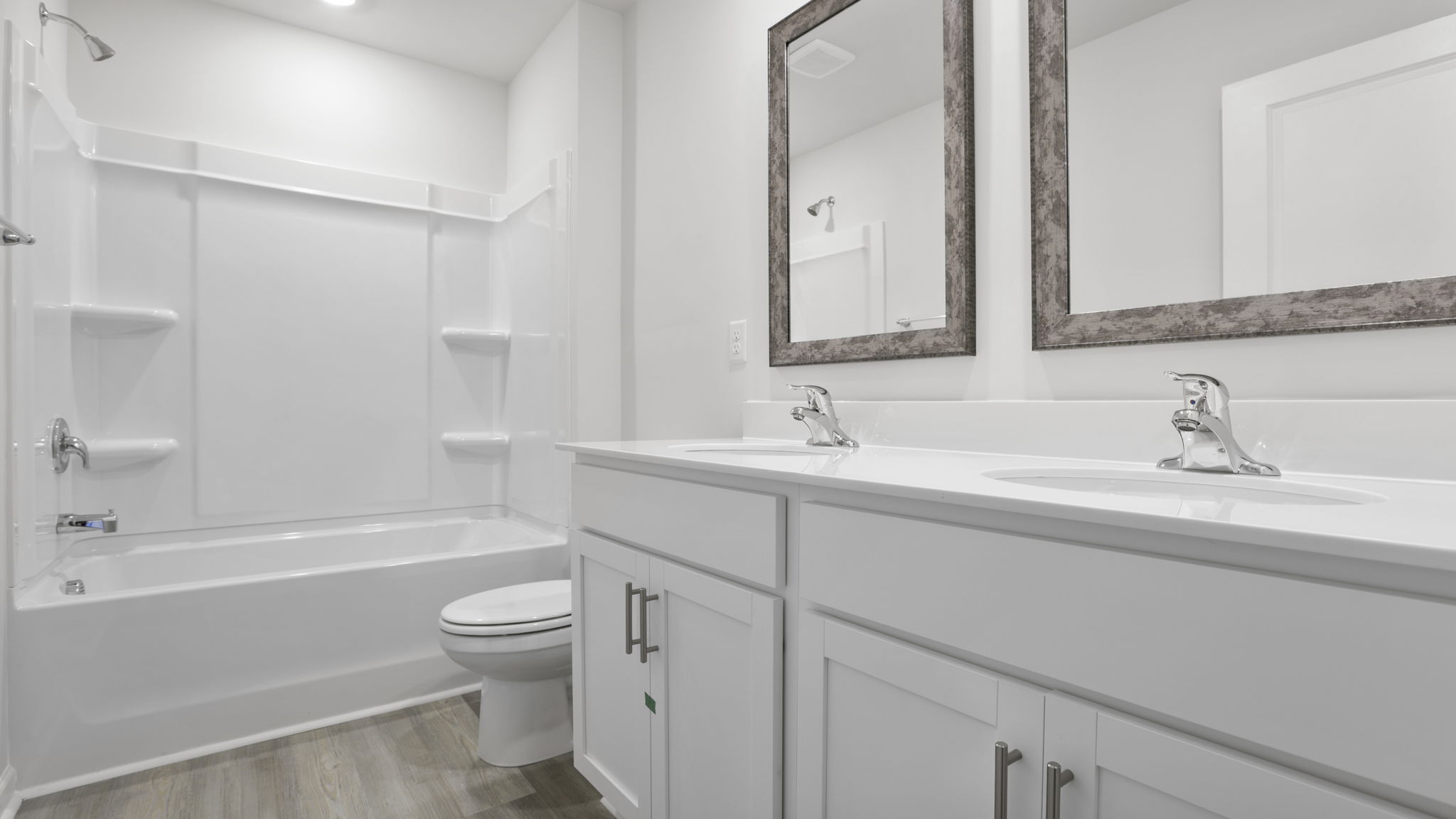 Hall bathroom with dual sink vanity and combination shower / tub.