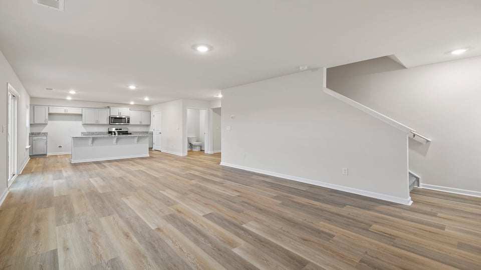 View of kitchen and stairwell from the living area.