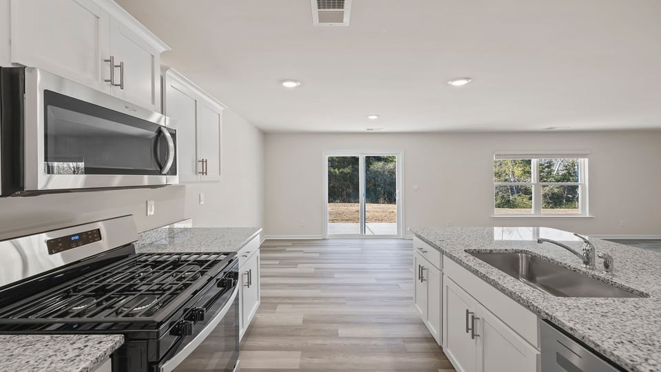 View from kitchen of the dining area and doors to the back patio.