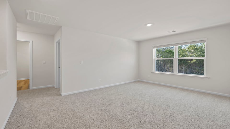Bedroom with large window and carpet on the main level.