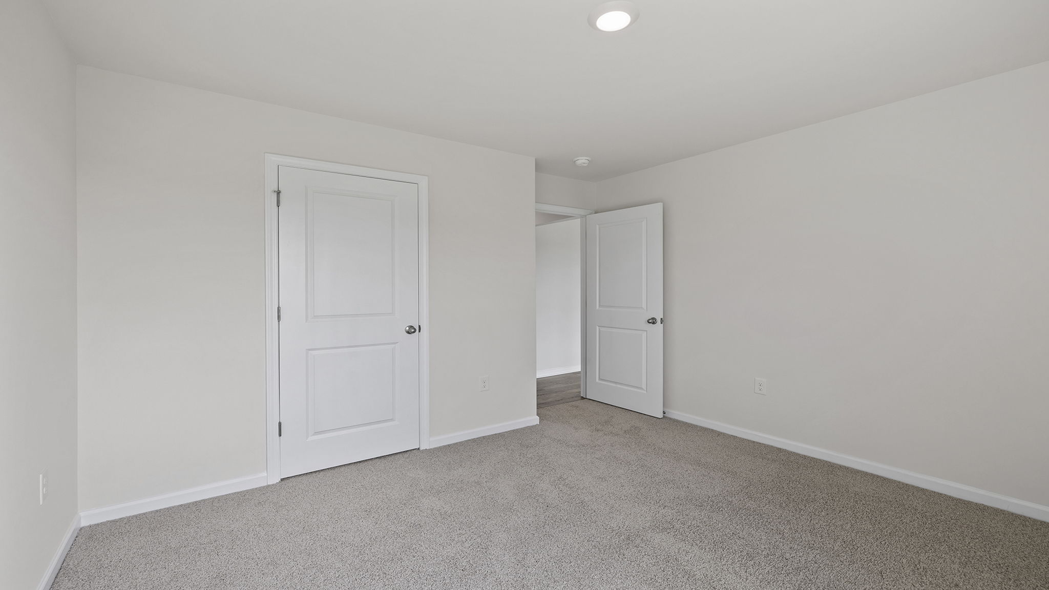 Main floor bedroom with window and carpet.