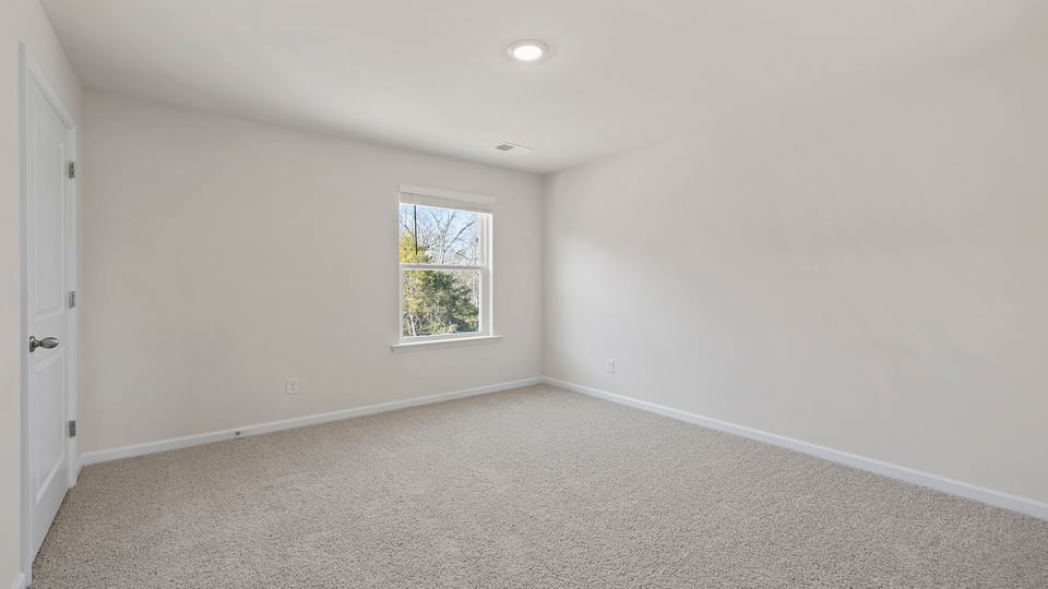 Bedroom with window and carpet.