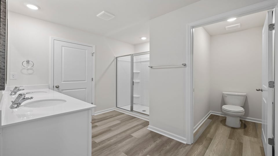 Primary bathroom with dual sink vanity and walk-in shower.