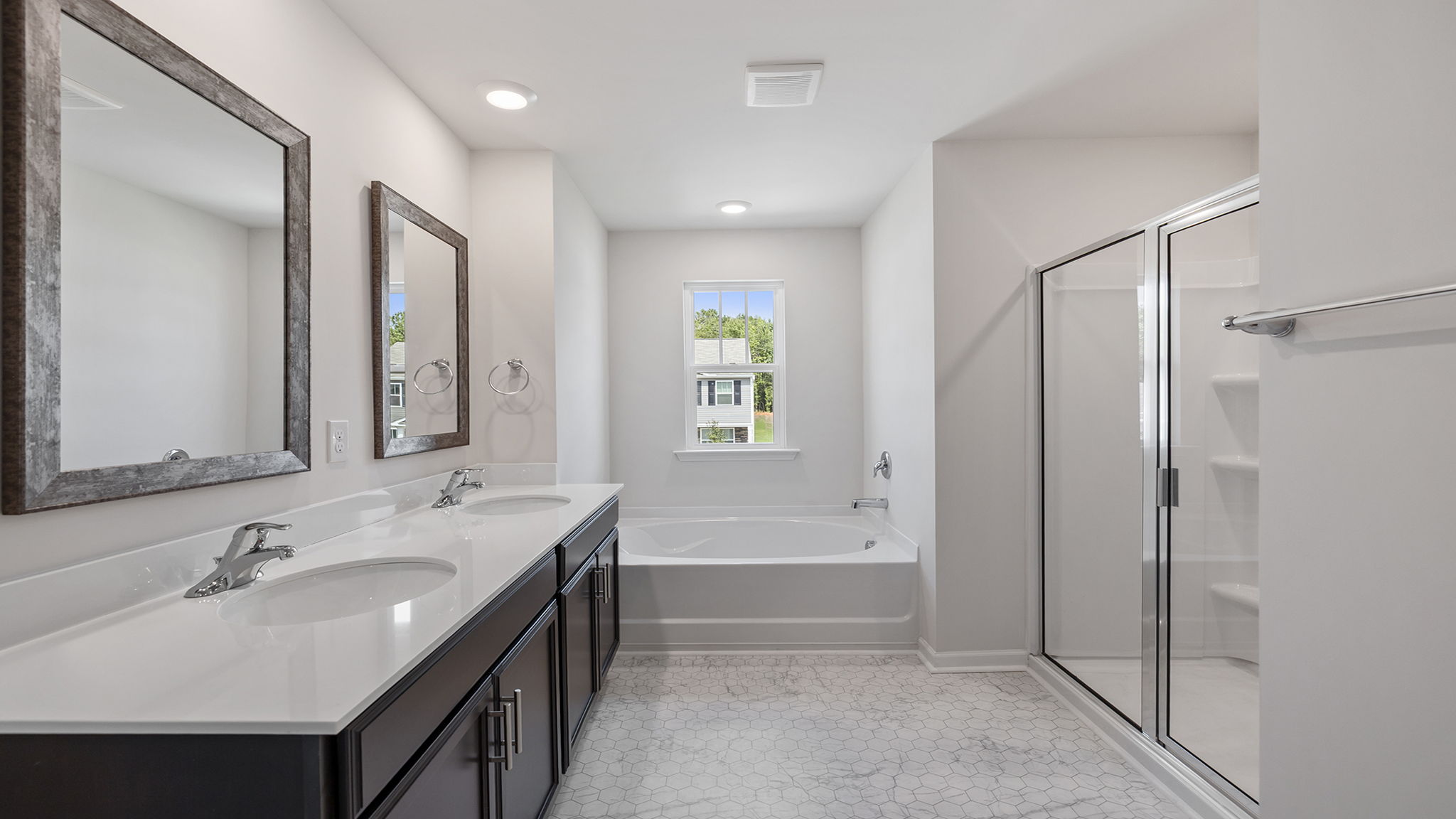Primary bathroom with dual sink vanity and walk-in shower.