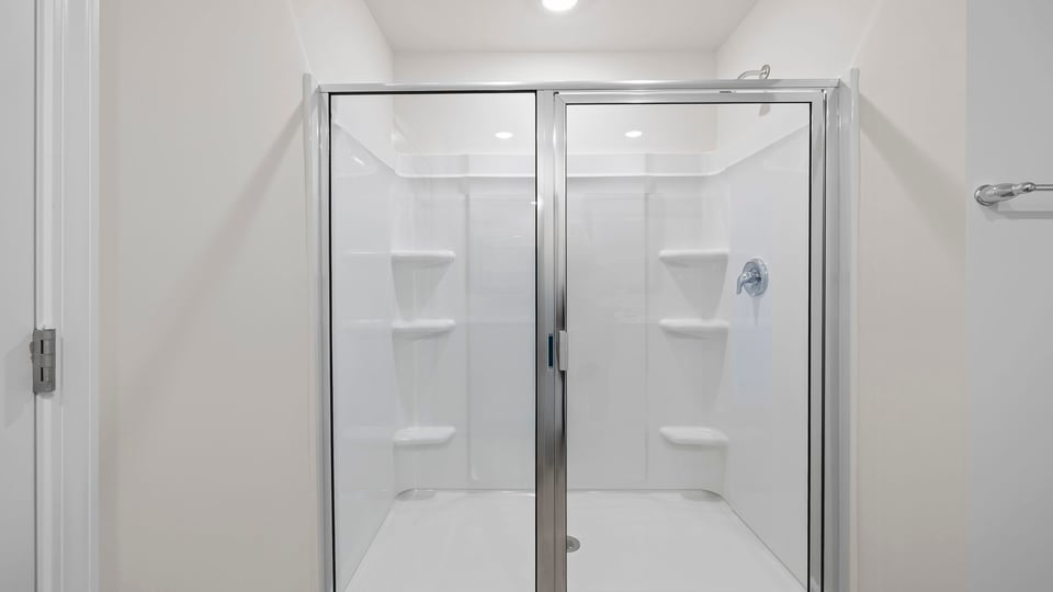 Primary bathroom with dual sink vanity and walk-in shower.