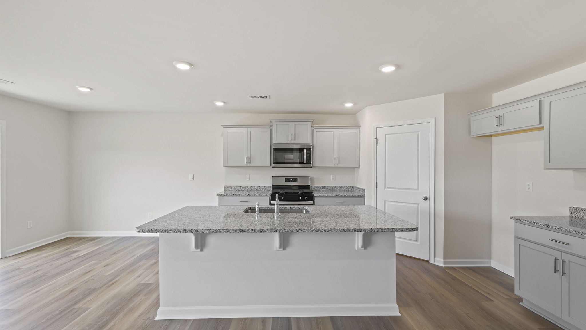 Open kitchen with island and quartz countertops.
