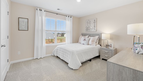 Bedroom with carpet and window.