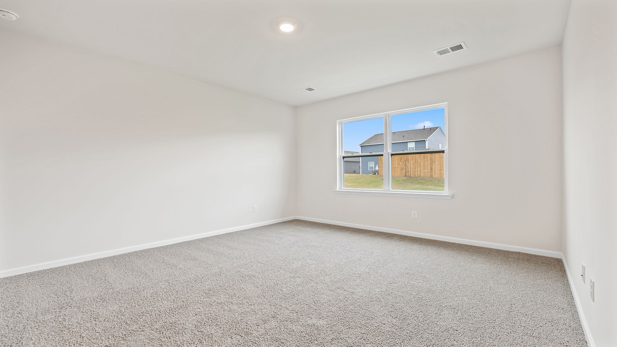 Primary bedroom with window and carpet.