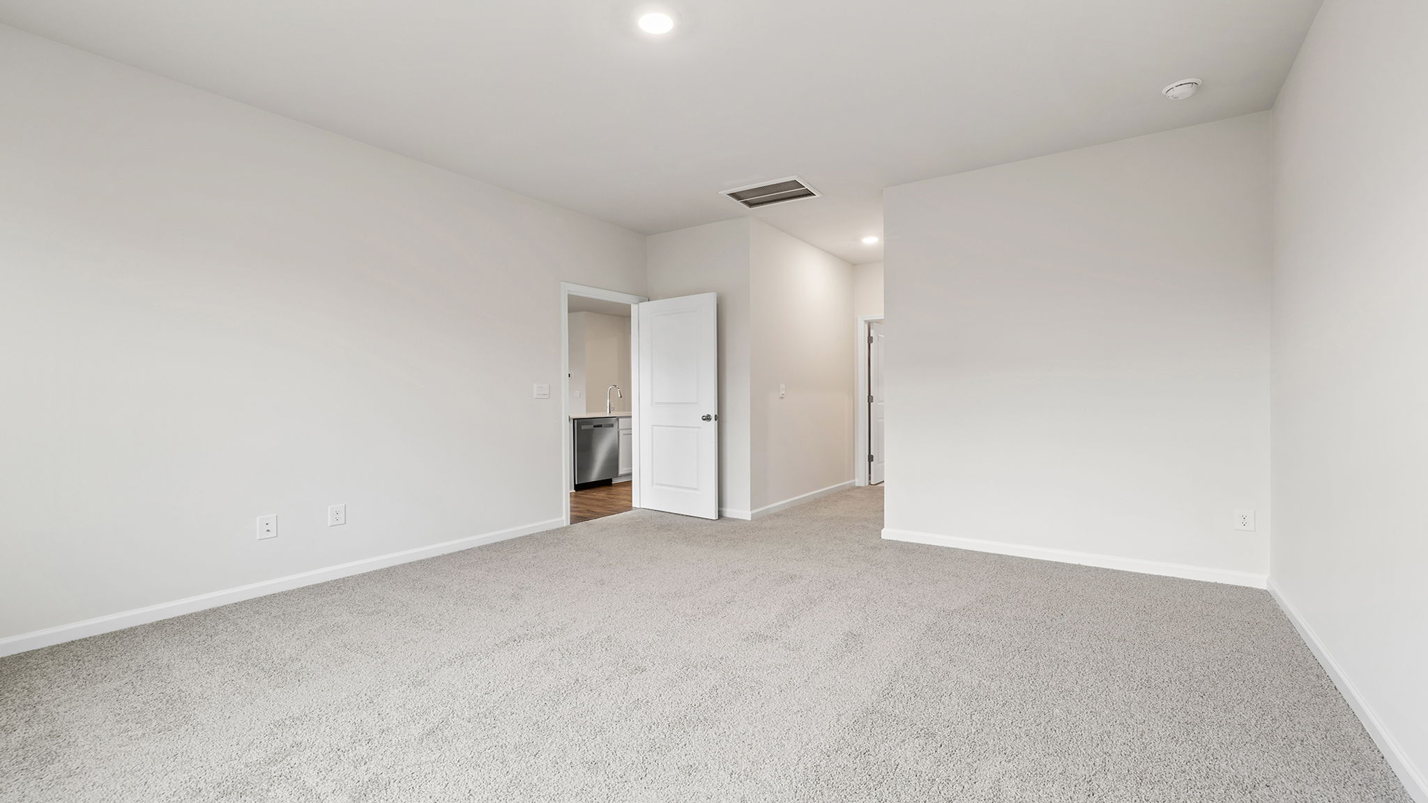 Primary bedroom with window and carpet.