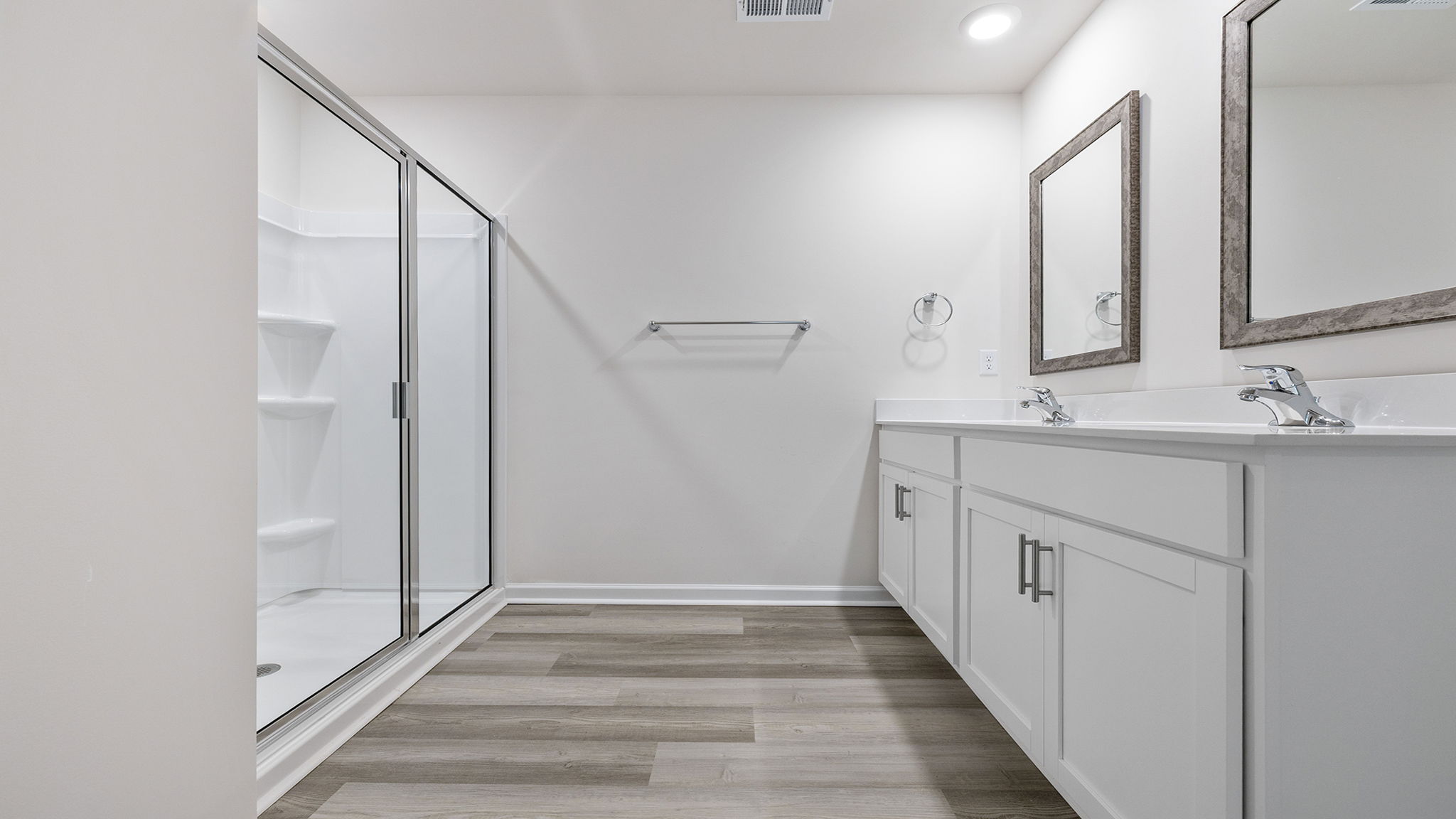 Primary bathroom with dual sink vanity and walk-in shower.