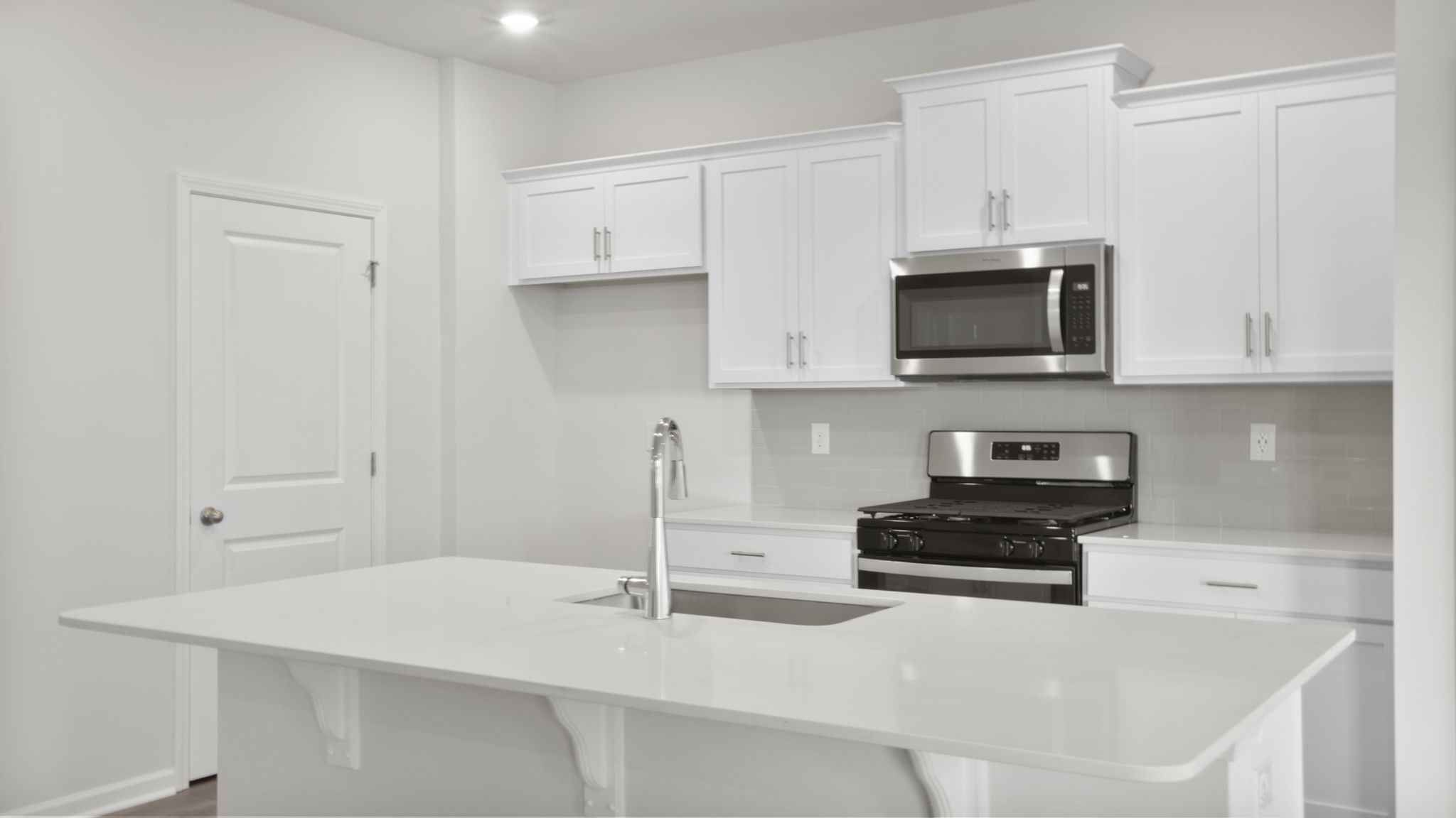 Kitchen and island have quartz countertops.