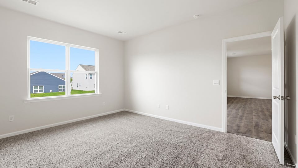 Bedroom with carpet and window.