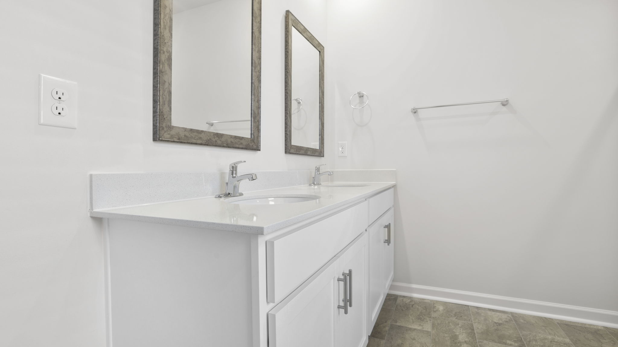 Primary bathroom with dual sink vanity and mirrors.