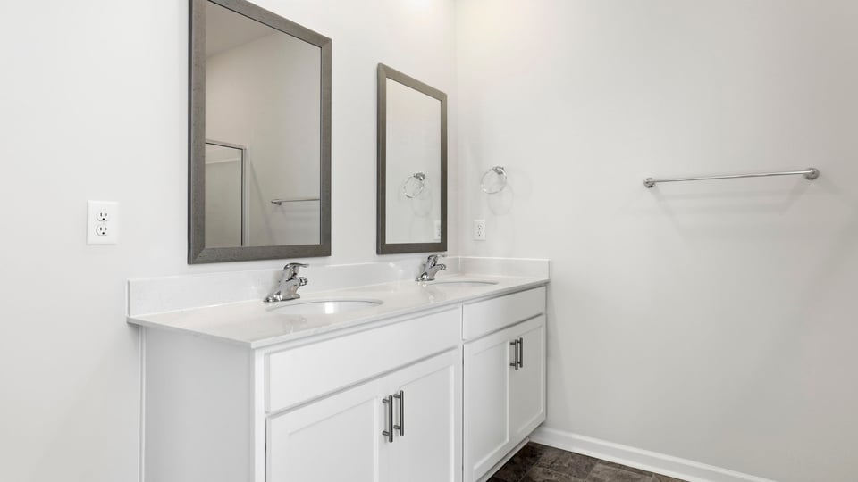 Bathroom with double vanity sink and walk in shower.