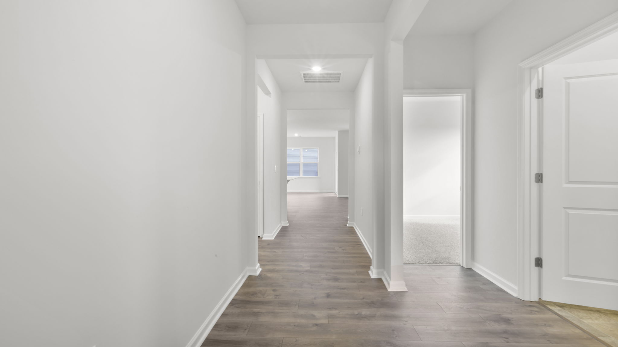 View of the hallway to the living area and entrance into a bedroom.