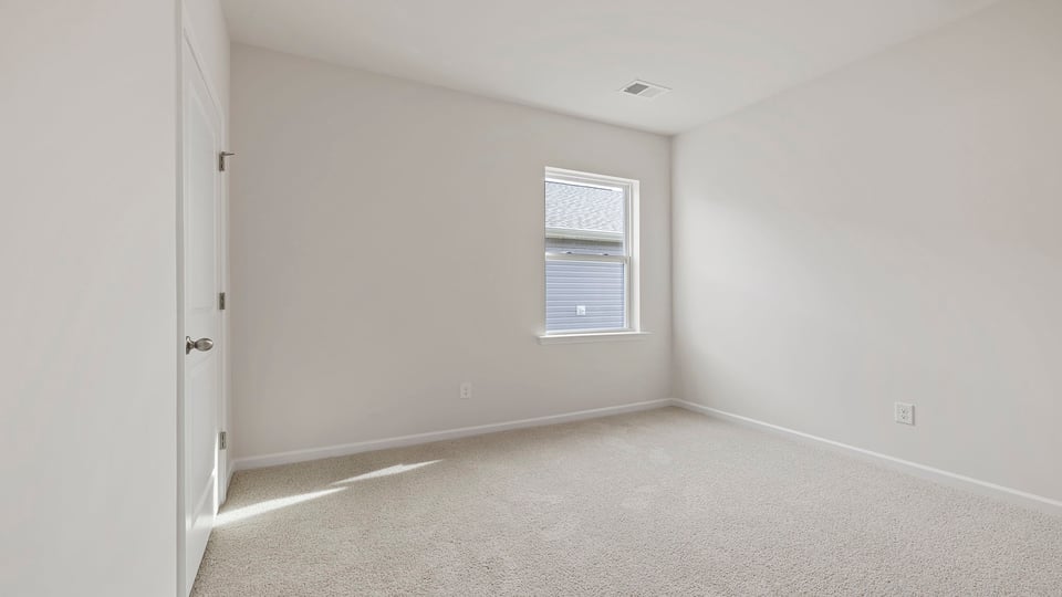 Bedroom with carpet and window.
