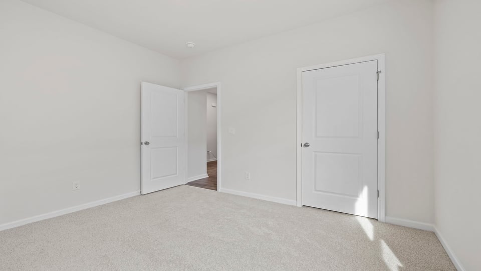 Bedroom with carpet and window.