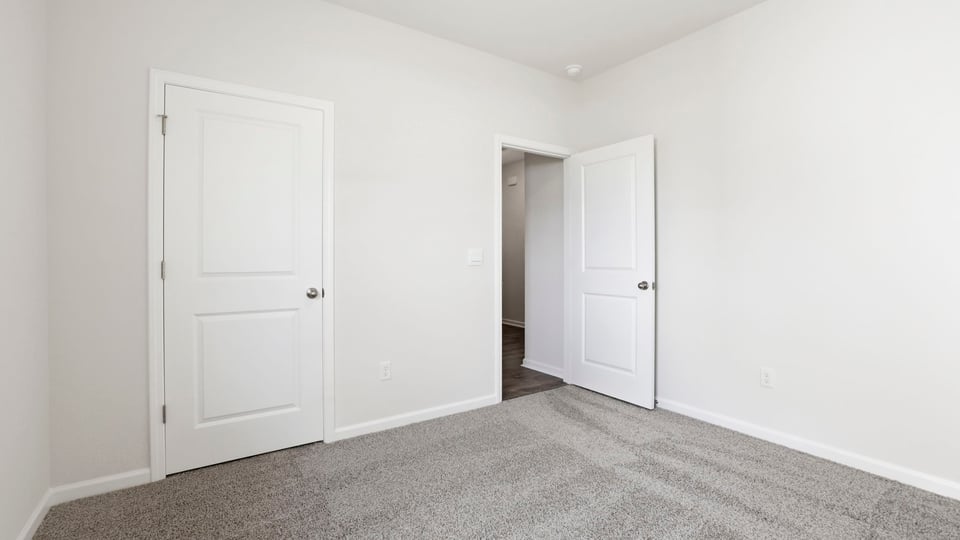 Bedroom with carpet and window.