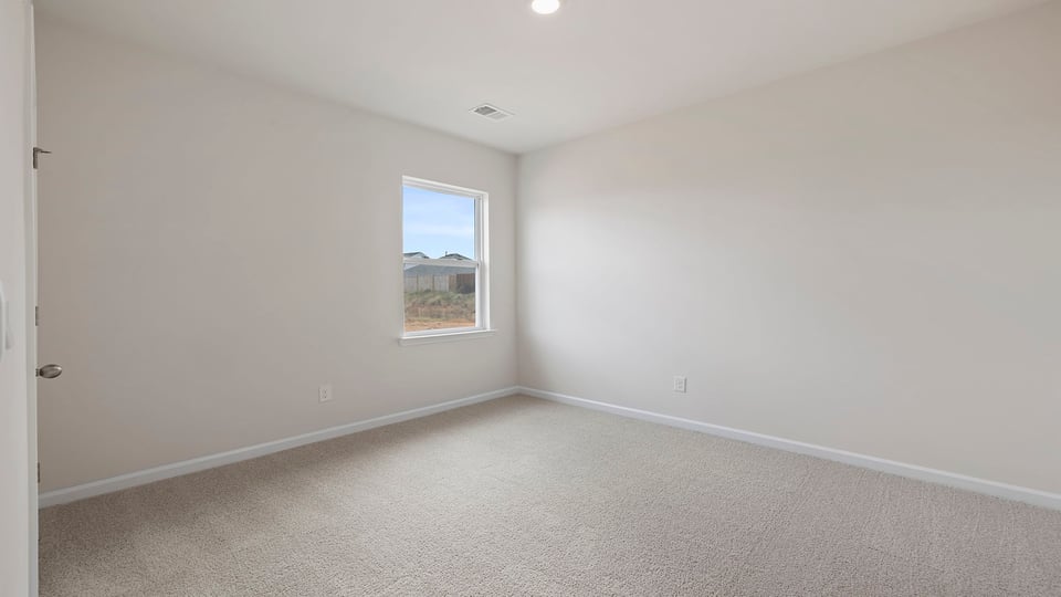 Bedroom with carpet and windows.