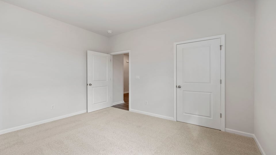 Bedroom with carpet and windows.