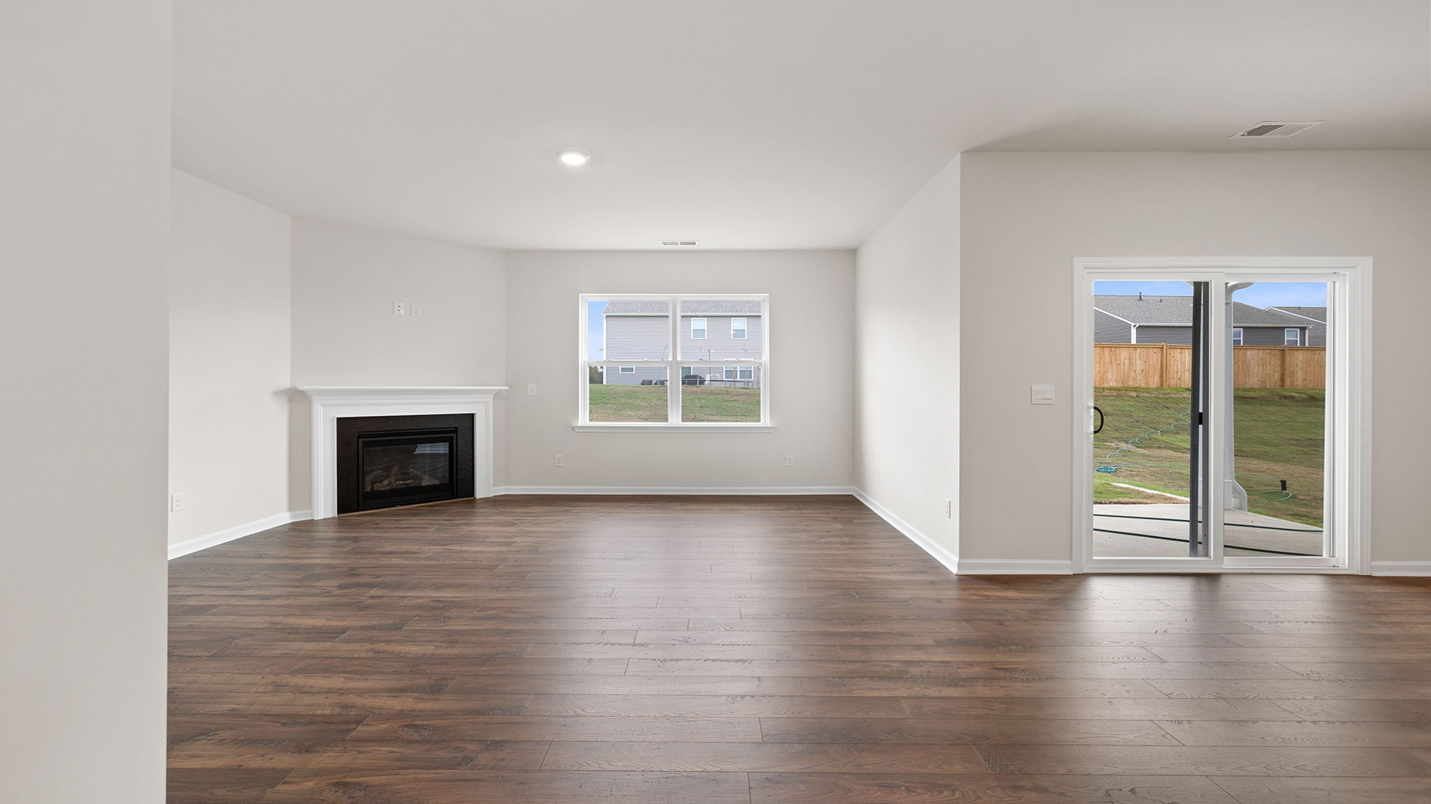 View of family room with large window and gas log fireplace.