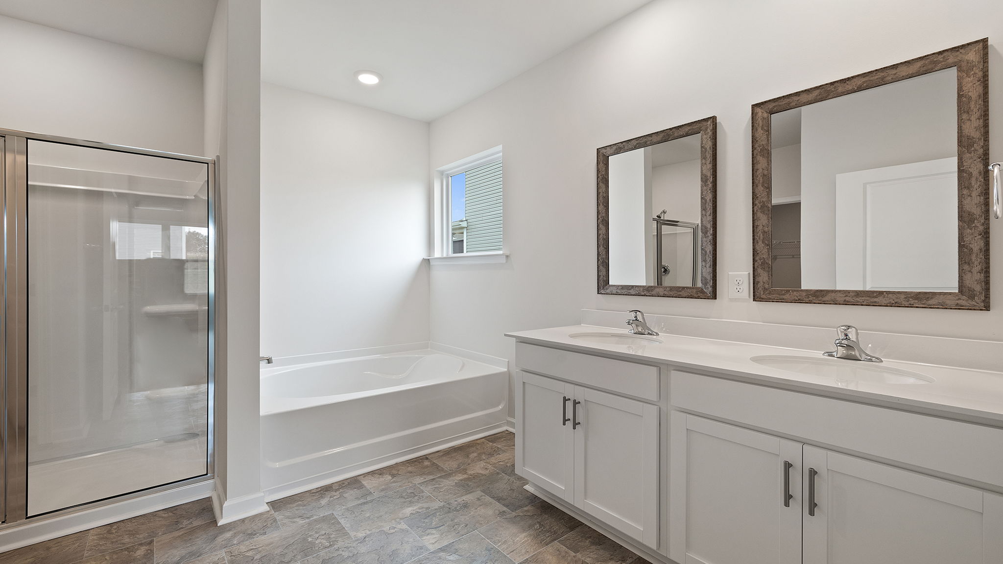 Primary bathroom with dual sink vanity and garden tub.