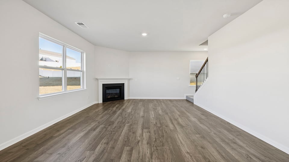 View of the family room with gas log fireplace and view of stairwell.