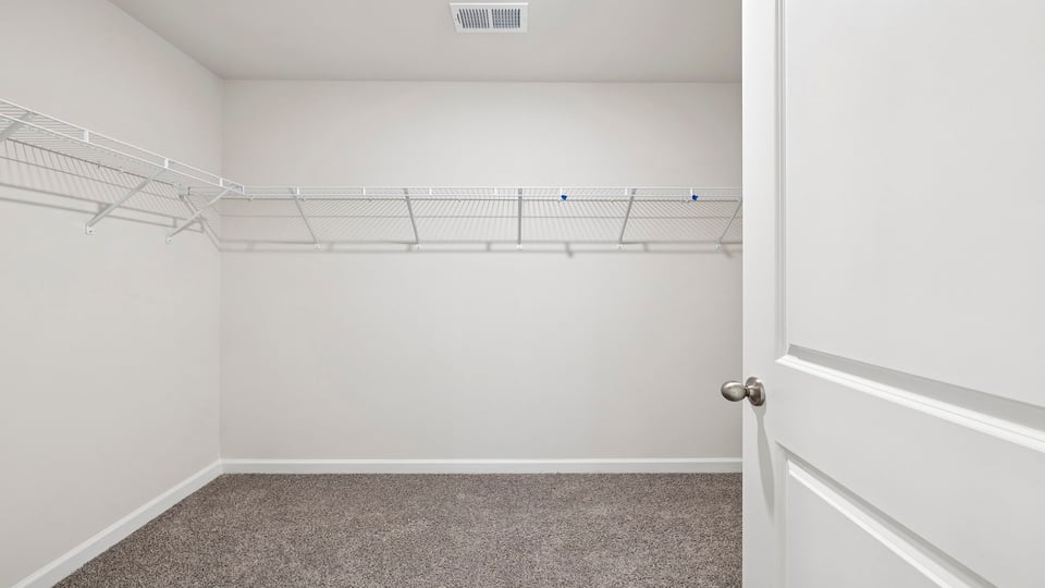 Primary bedroom walk-in closet with shelving.