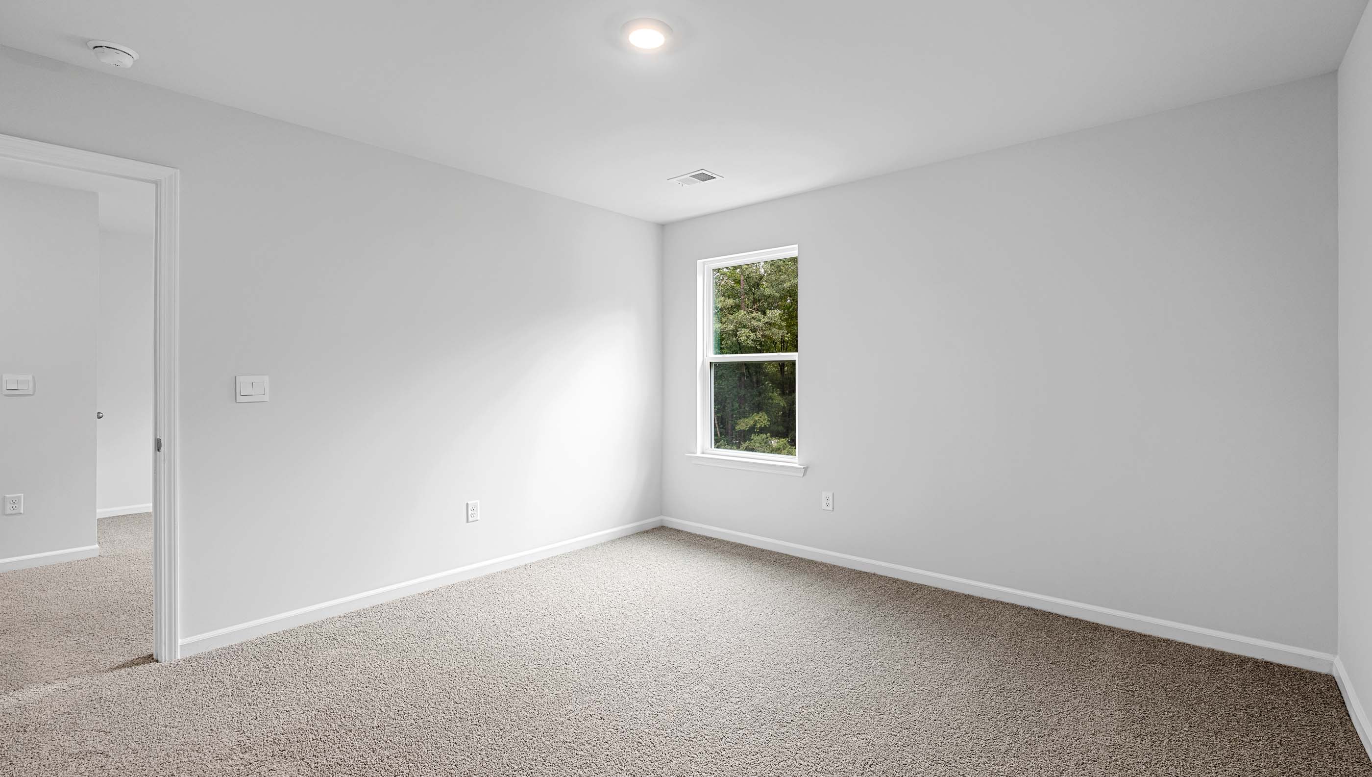 Bedroom with window and carpet.