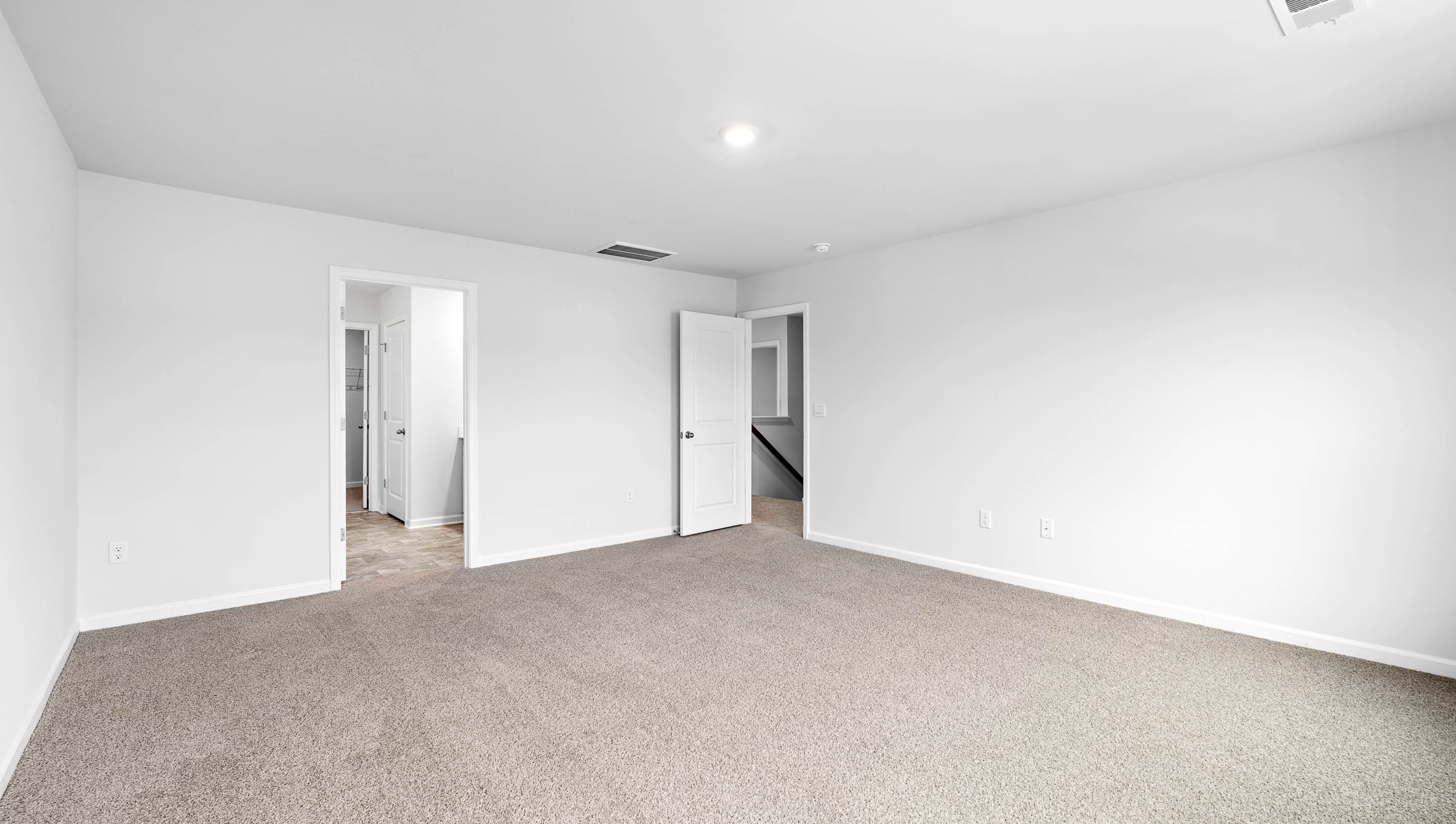 Primary bedroom with double windows and carpet.