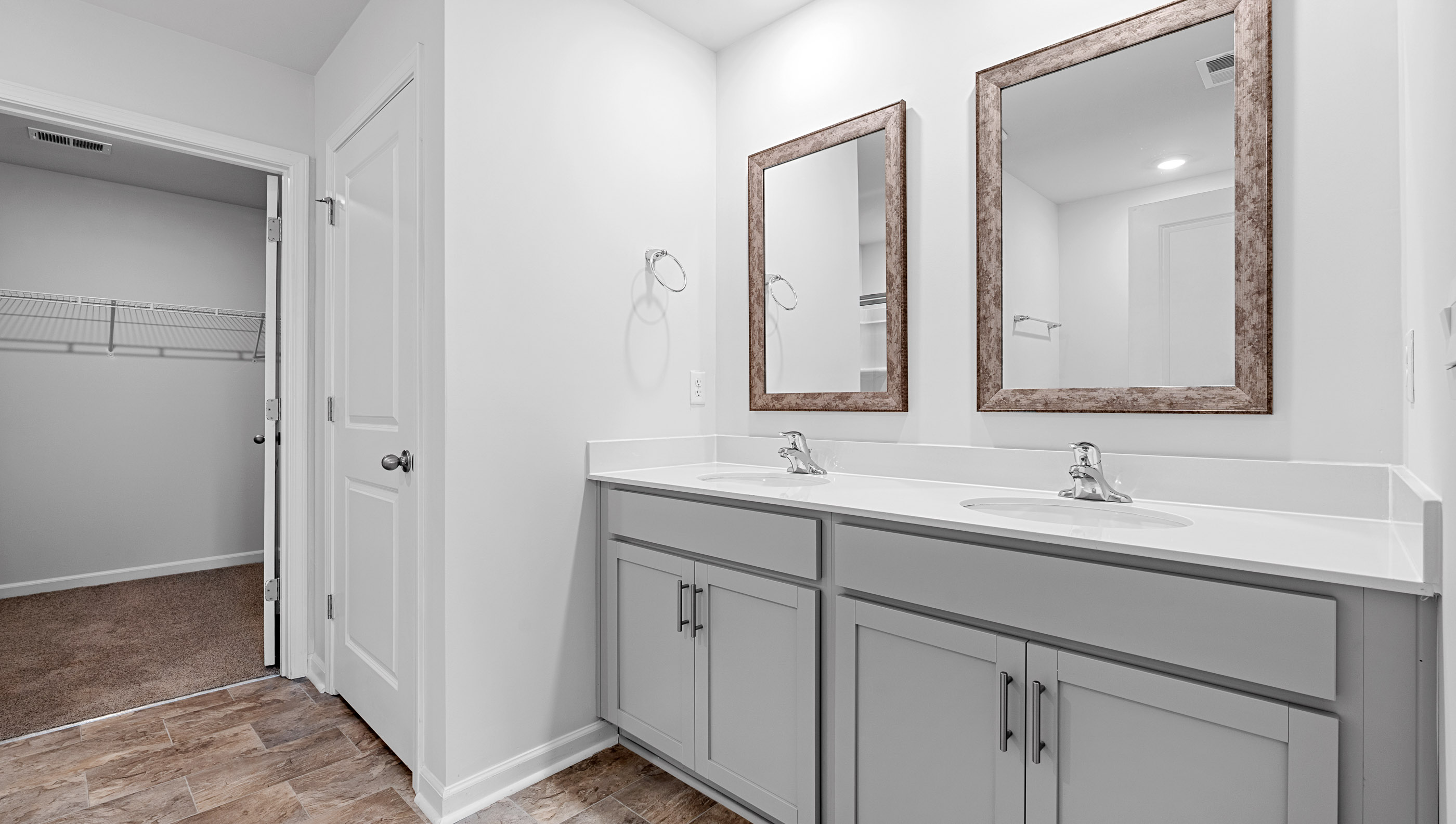 Primary bathroom dual sink vanity and mirrors.