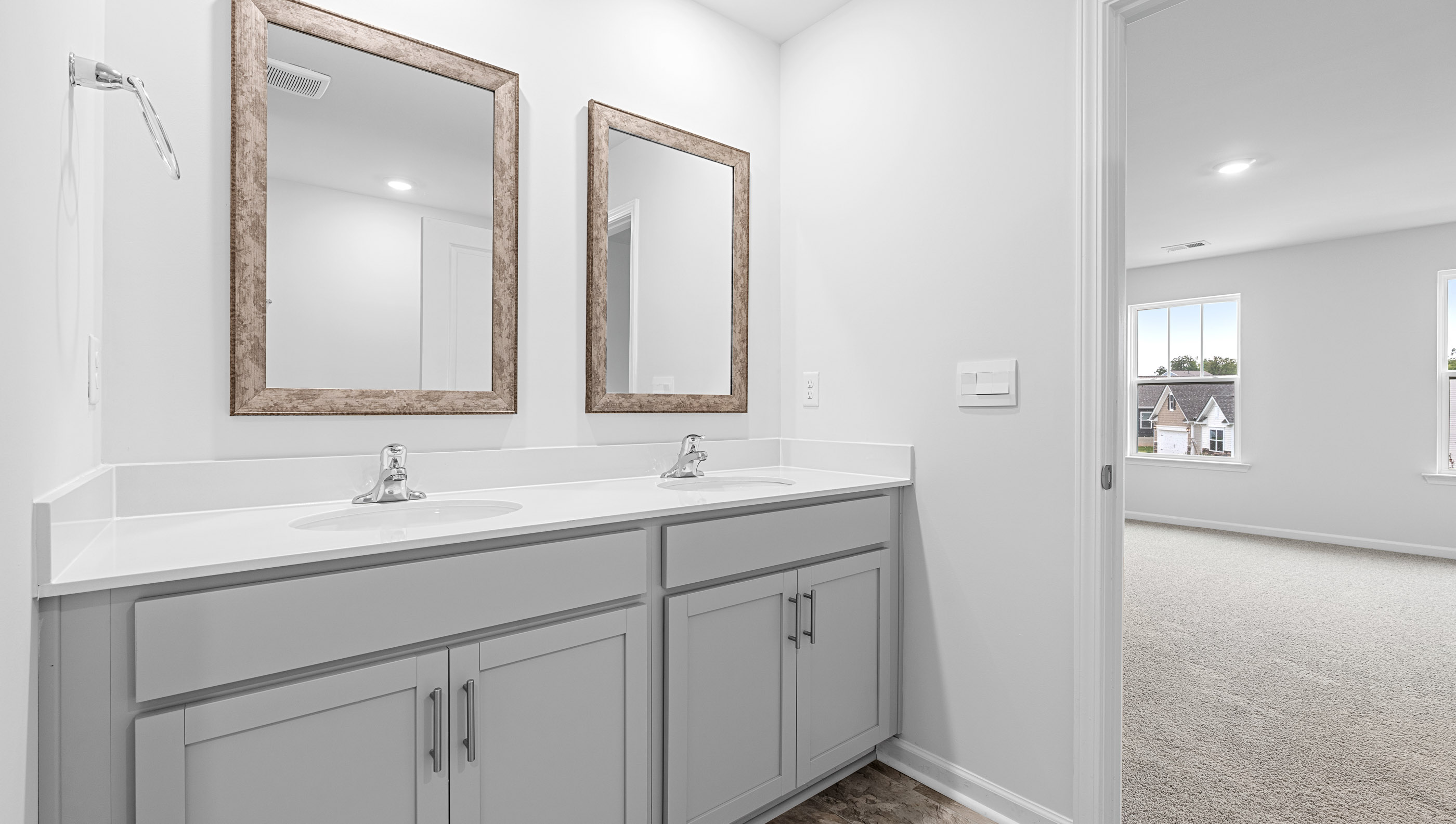 Primary bathroom with dual sink vanity and mirrors.