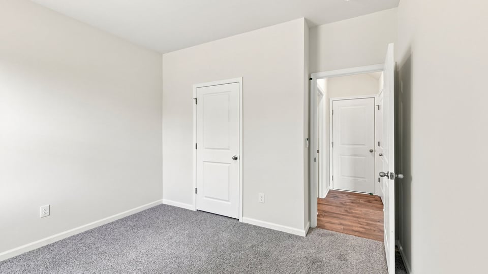 Bedroom with carpet and windows.