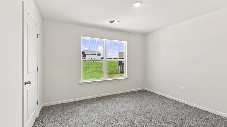 Bedroom with carpet and windows.