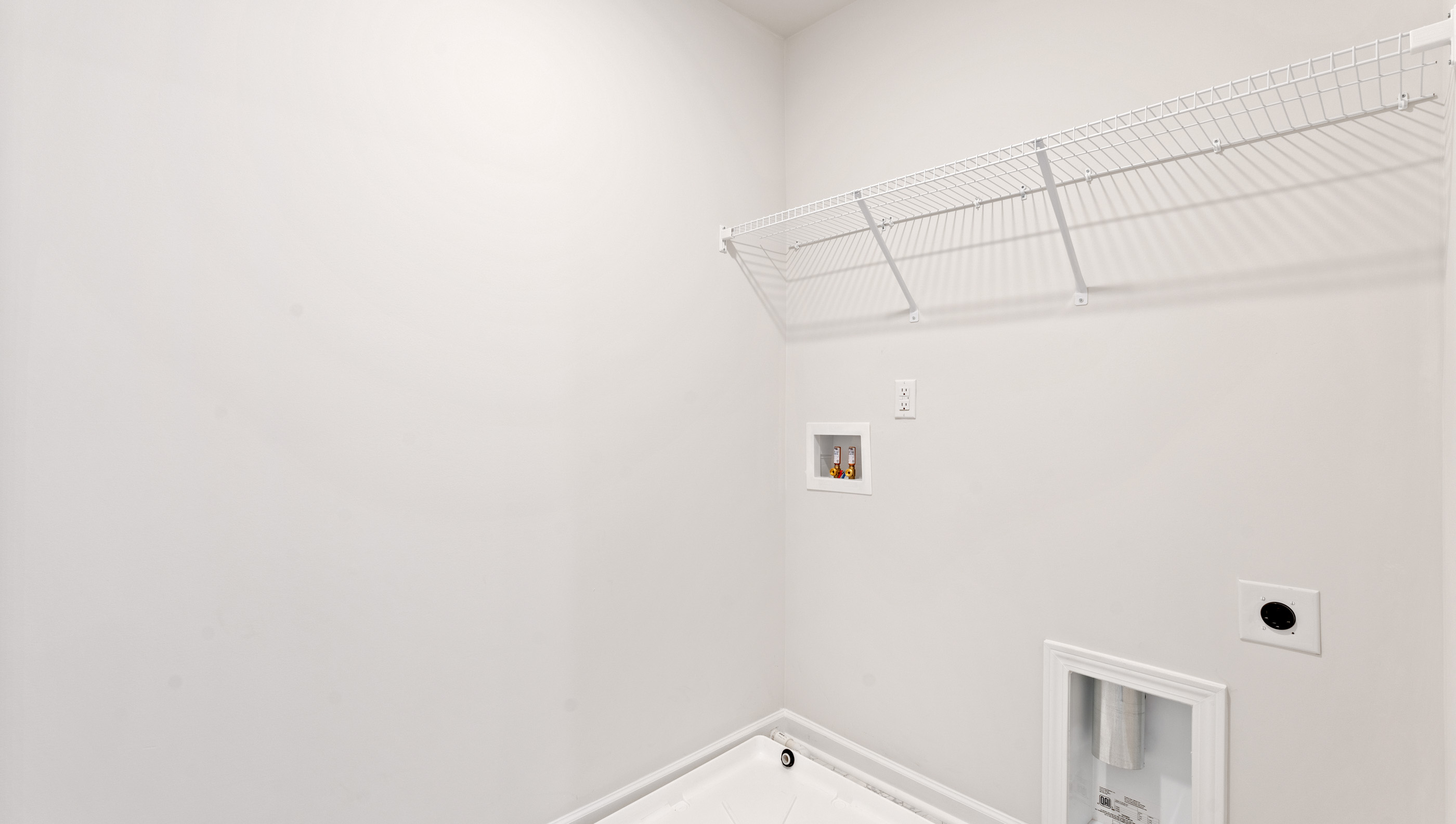 Walk-in laundry room with shelving.