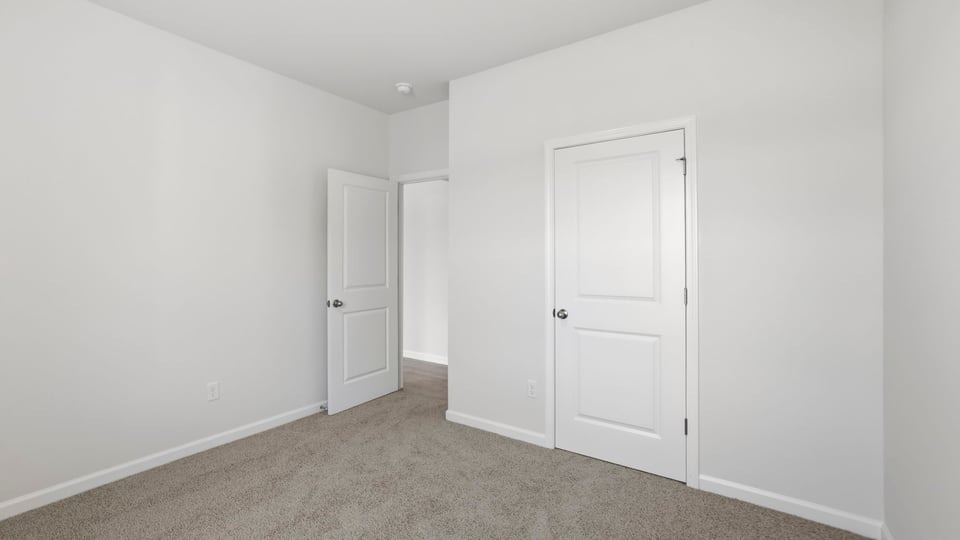 Bedroom with carpet and windows.