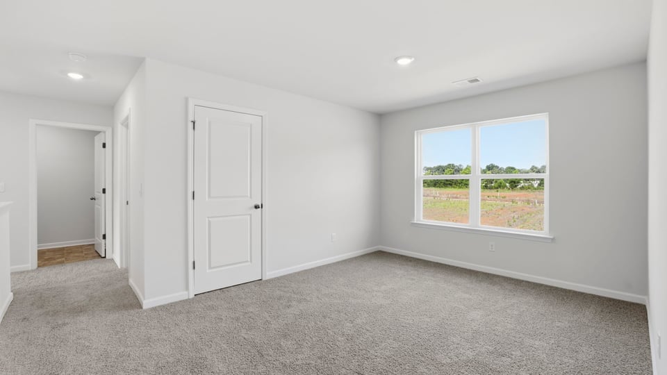 Bedroom with carpet and windows.
