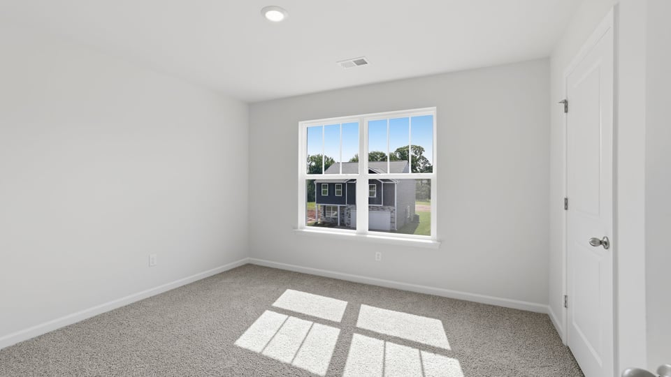 Bedroom with carpet and windows.