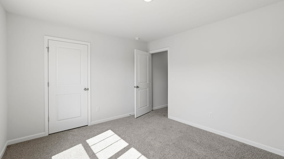 Bedroom with carpet and windows.