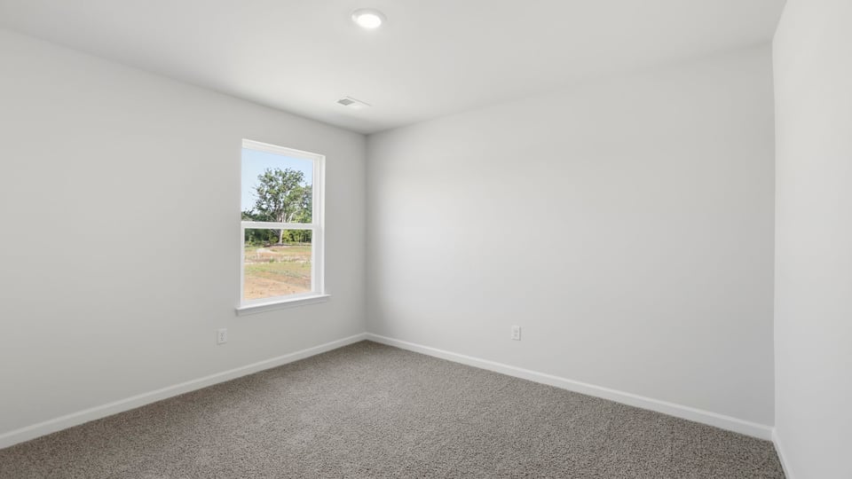 Bedroom with carpet and windows.