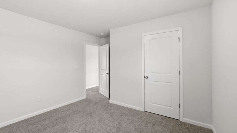 Bedroom with carpet and windows.