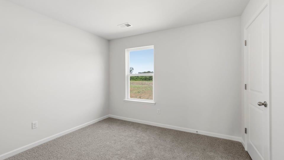 Bedroom with carpet and windows.