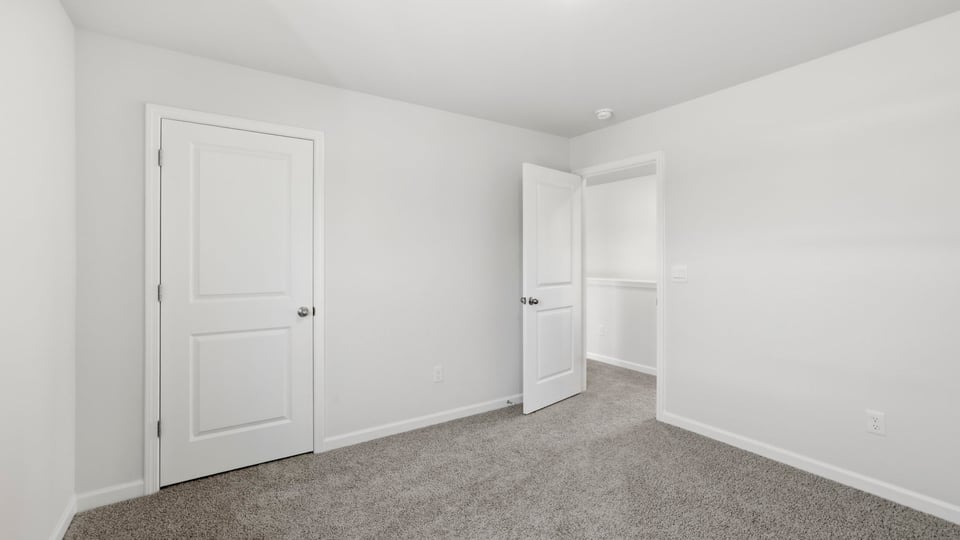 Bedroom with carpet and windows.