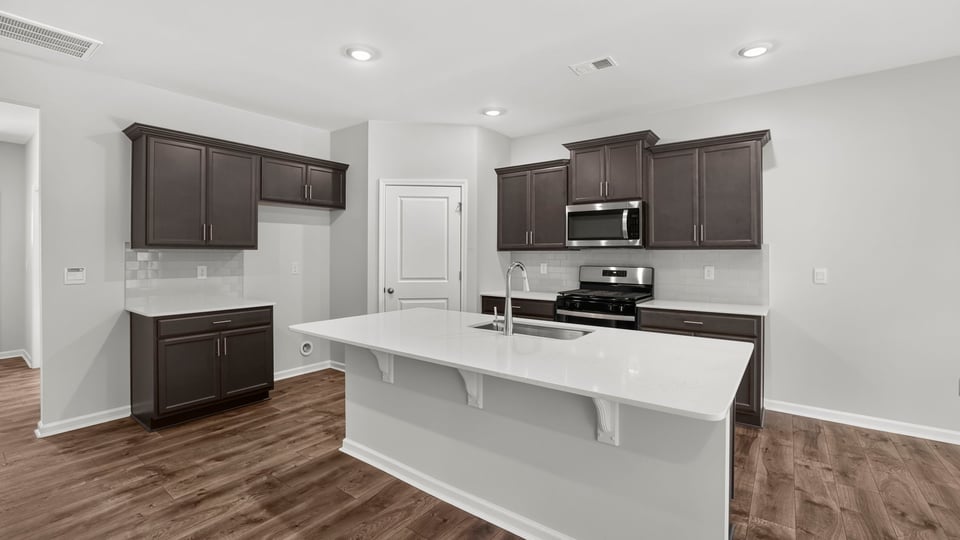 Kitchen and island with quartz countertops.