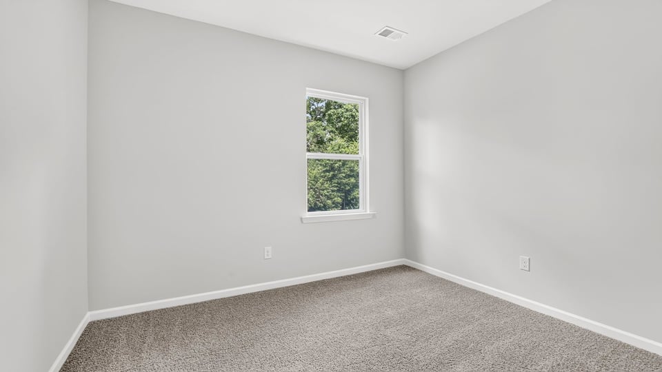 Bedroom with carpet and window.
