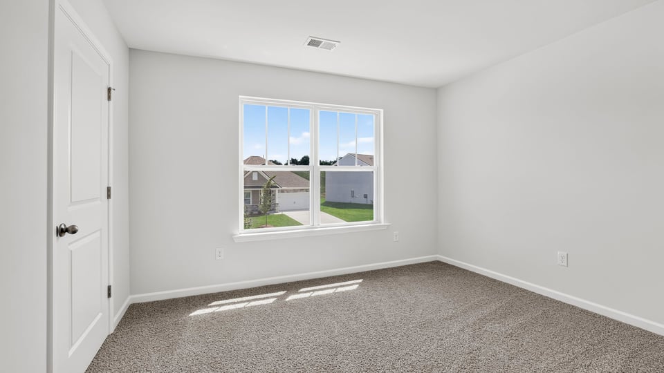 Bedroom with carpet and window.